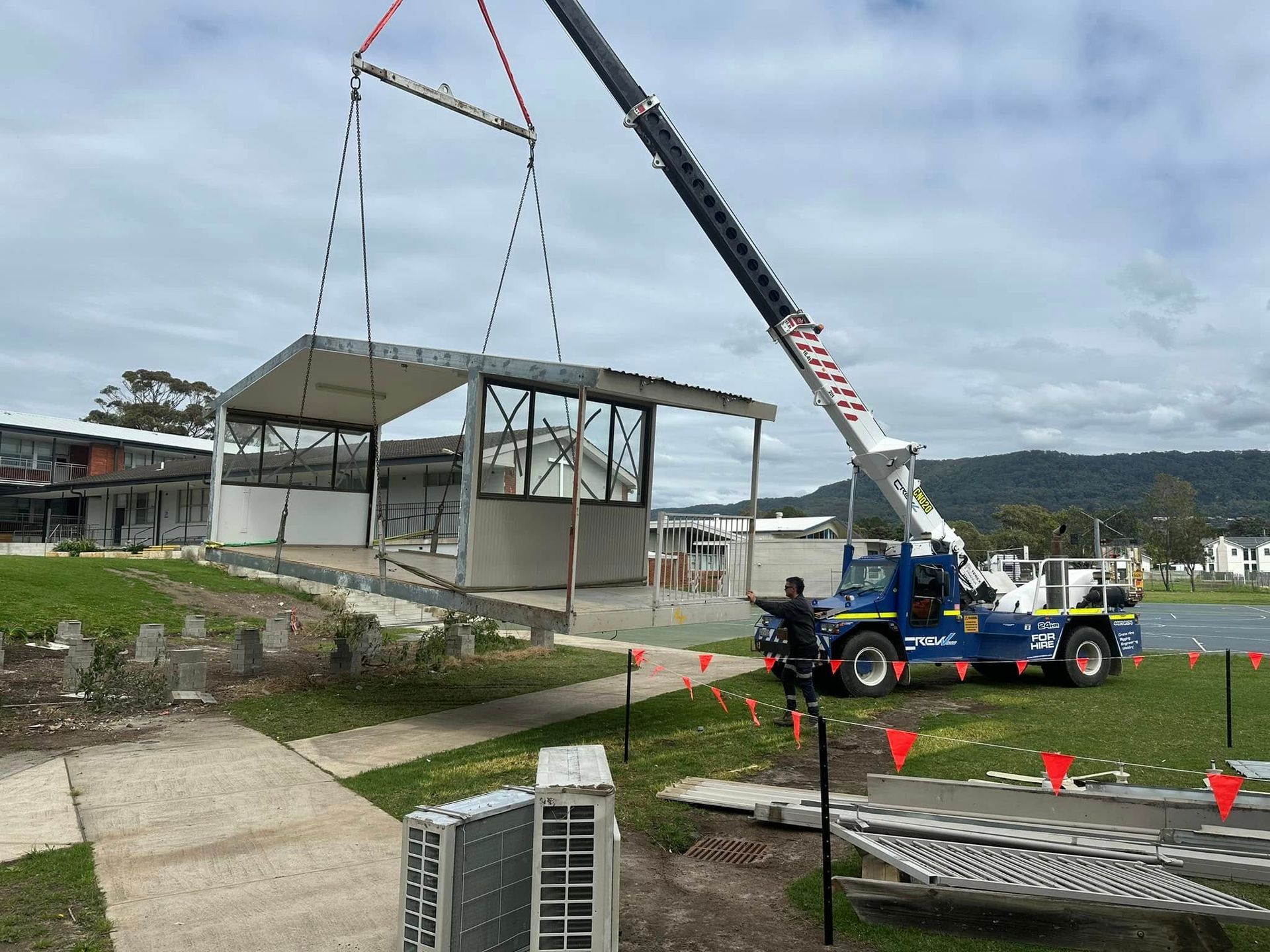 A crane is lifting a building in the air.