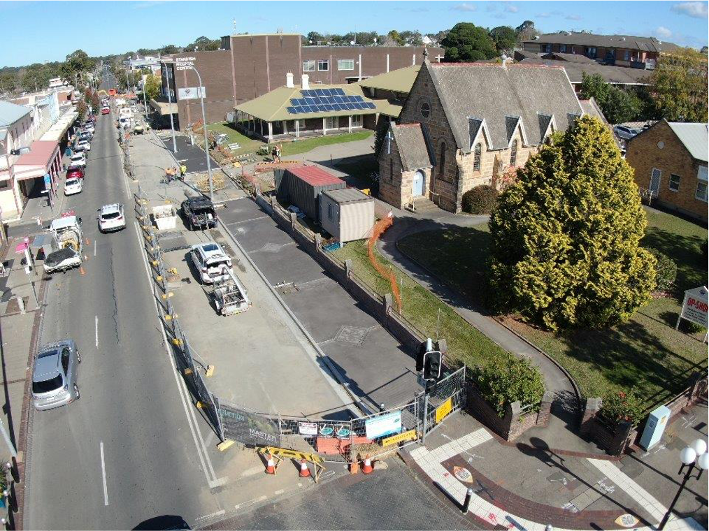 An aerial view of a street with a church in the background