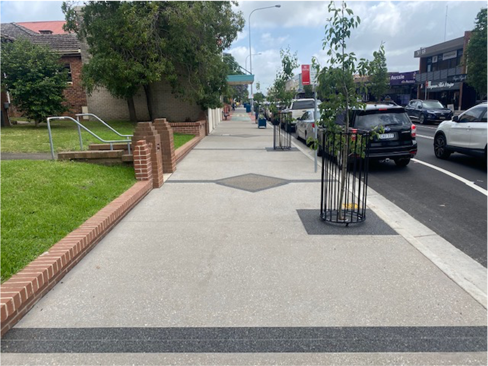 A sidewalk with a tree in the middle of it