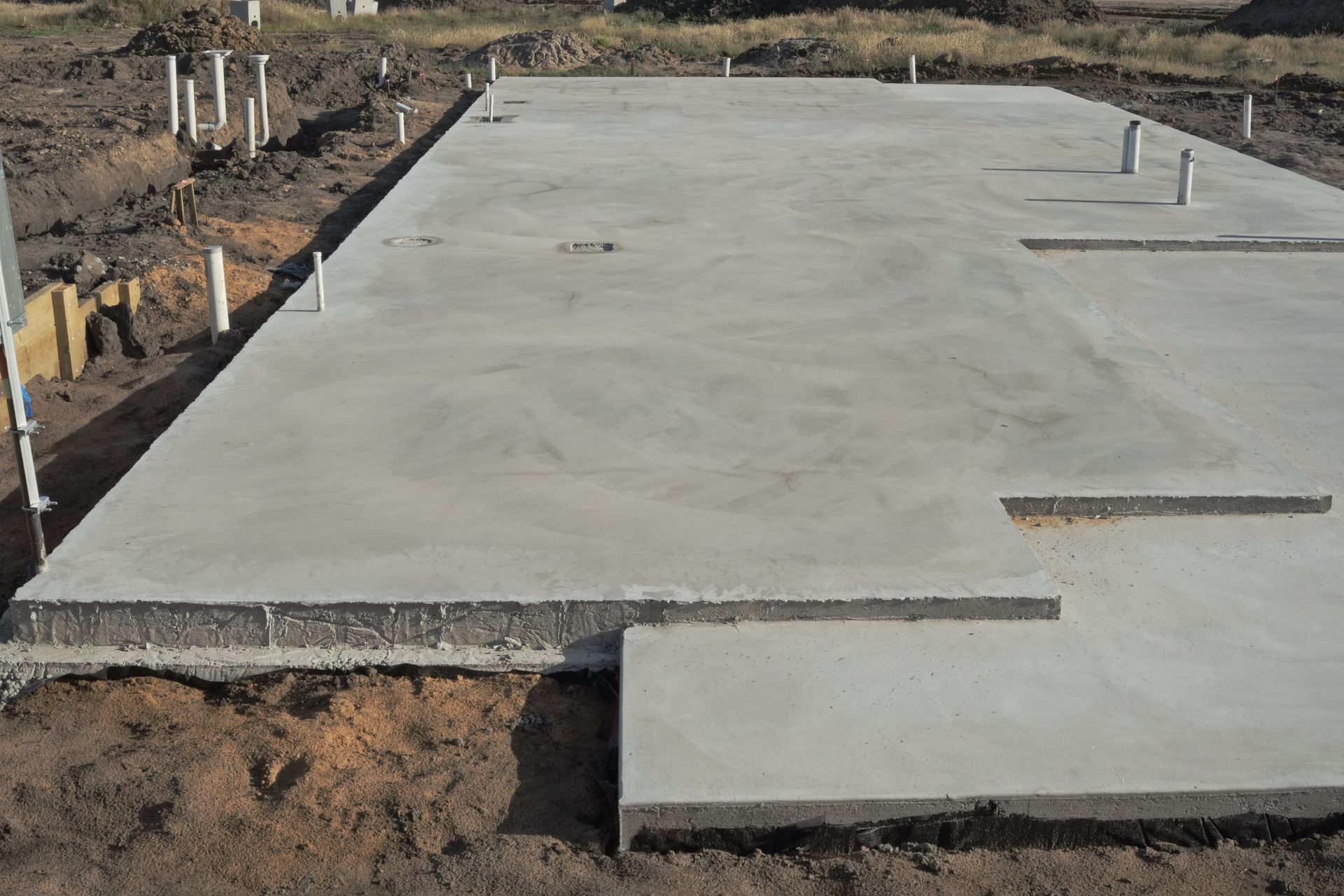 A large concrete slab is sitting on top of a dirt field.