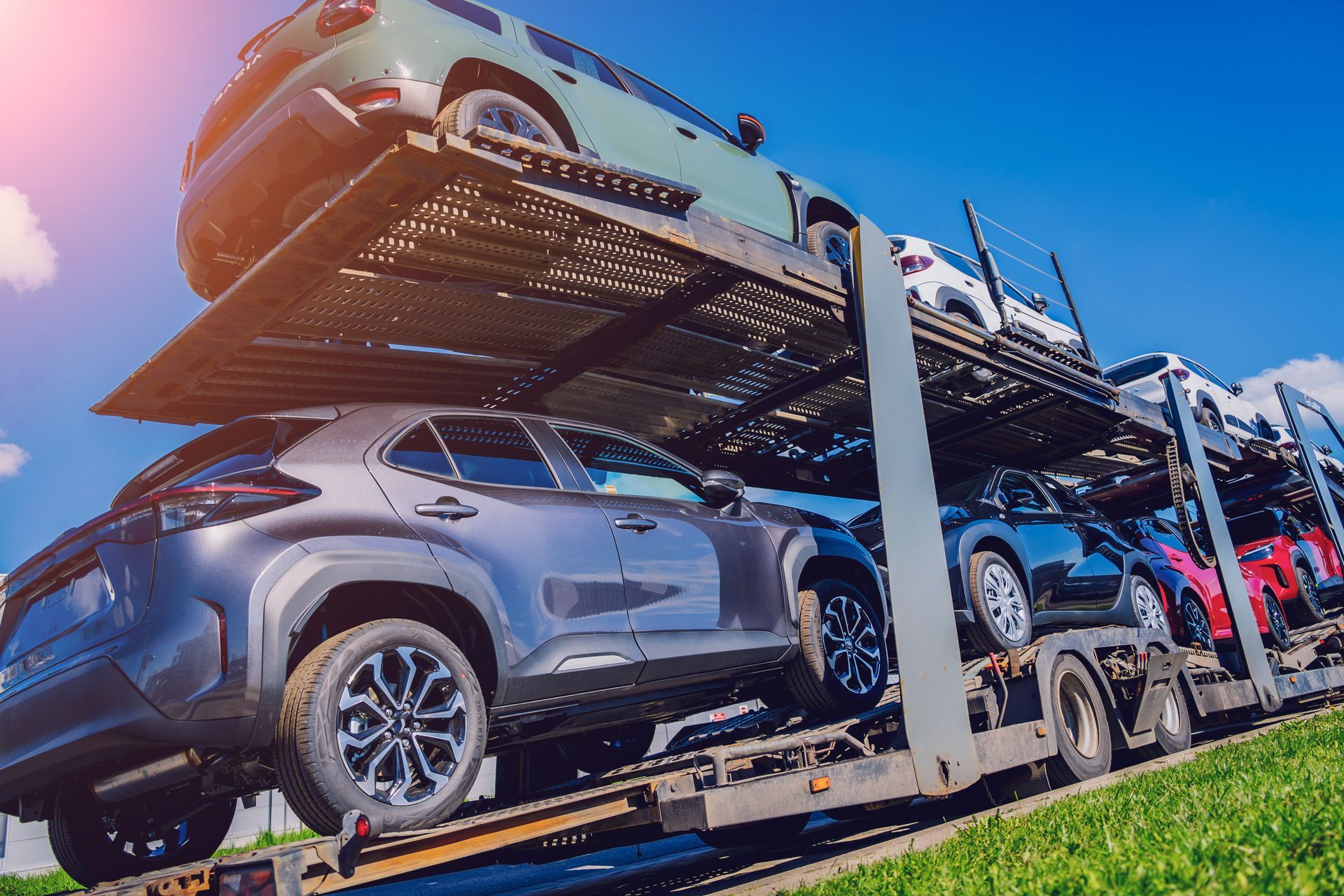 A car transporter is carrying a stack of cars on top of each other.