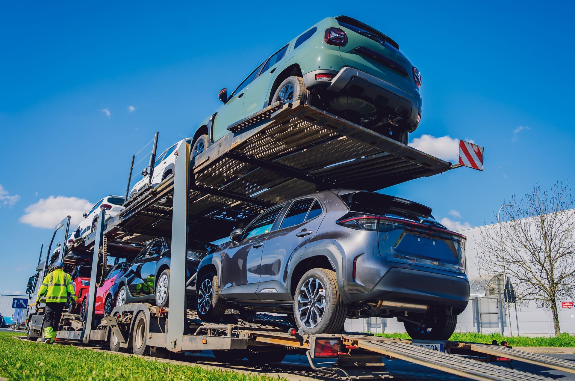 A truck is carrying a bunch of cars on a highway.