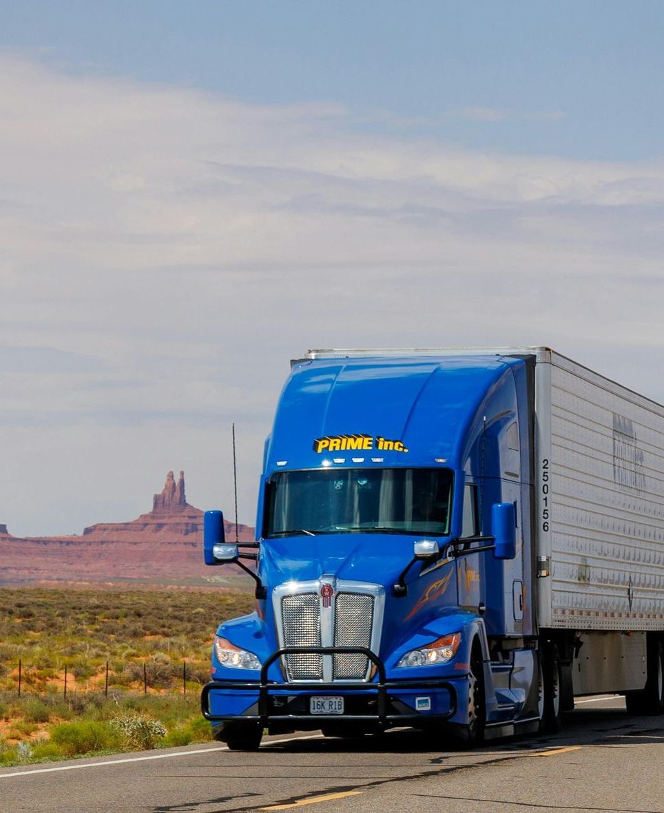 A blue semi truck with the word prime on the front