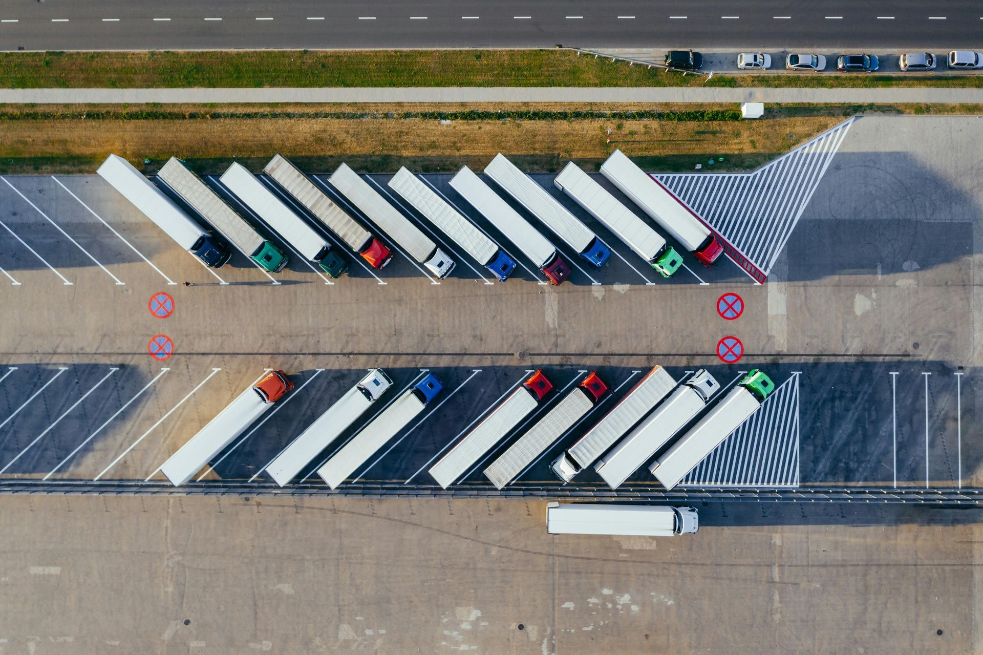 An aerial view of a parking lot with trucks parked in a row.