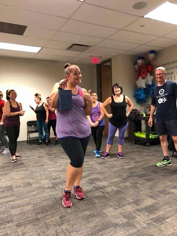 A group of people are dancing in a gym.