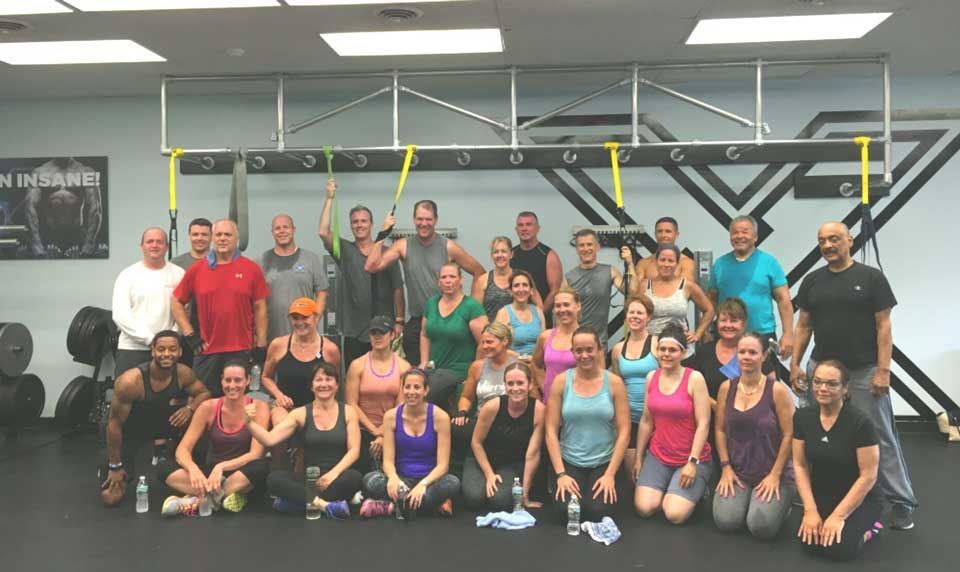 A group of people are posing for a picture in a gym.