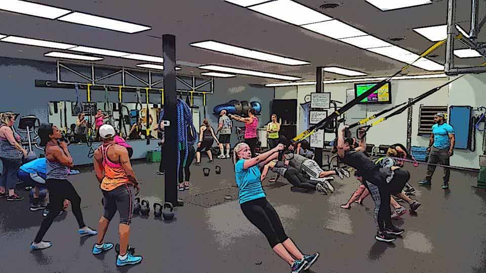 A group of people are doing exercises in a gym.