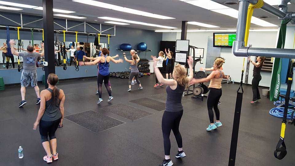 A group of people are dancing in a gym.