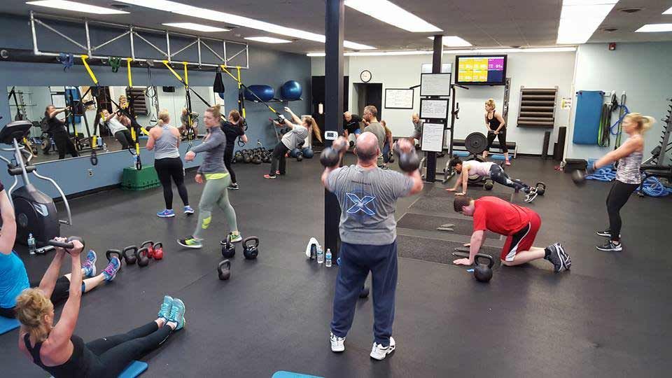 A group of people are doing exercises in a gym.