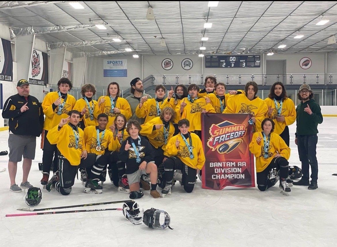 A hockey team is posing for a picture on the ice.