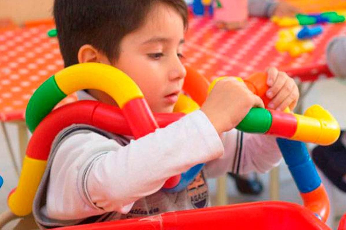 Un niño está jugando con una pipa de juguete de colores.