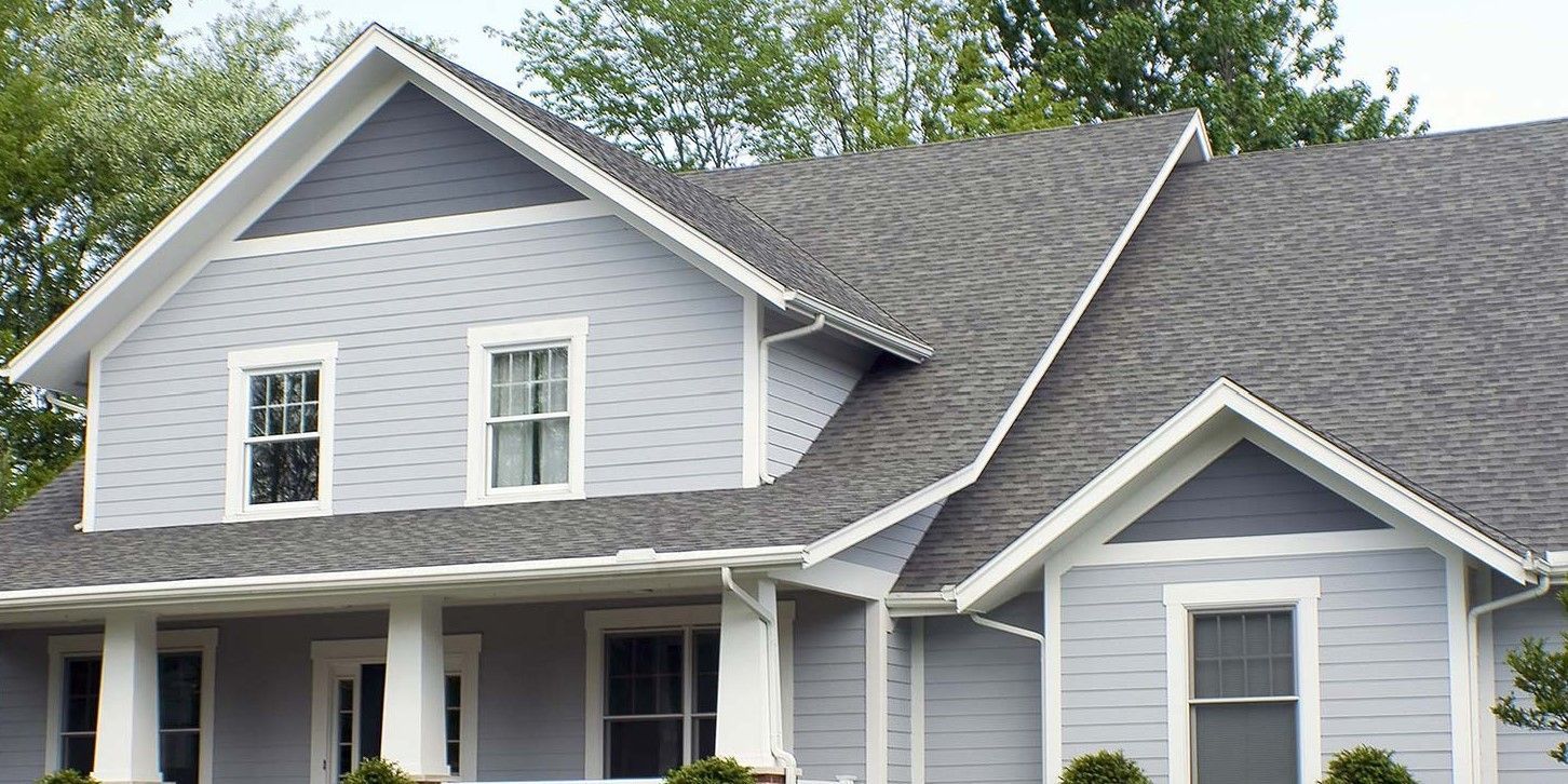 A large gray house with a gray roof and white trim