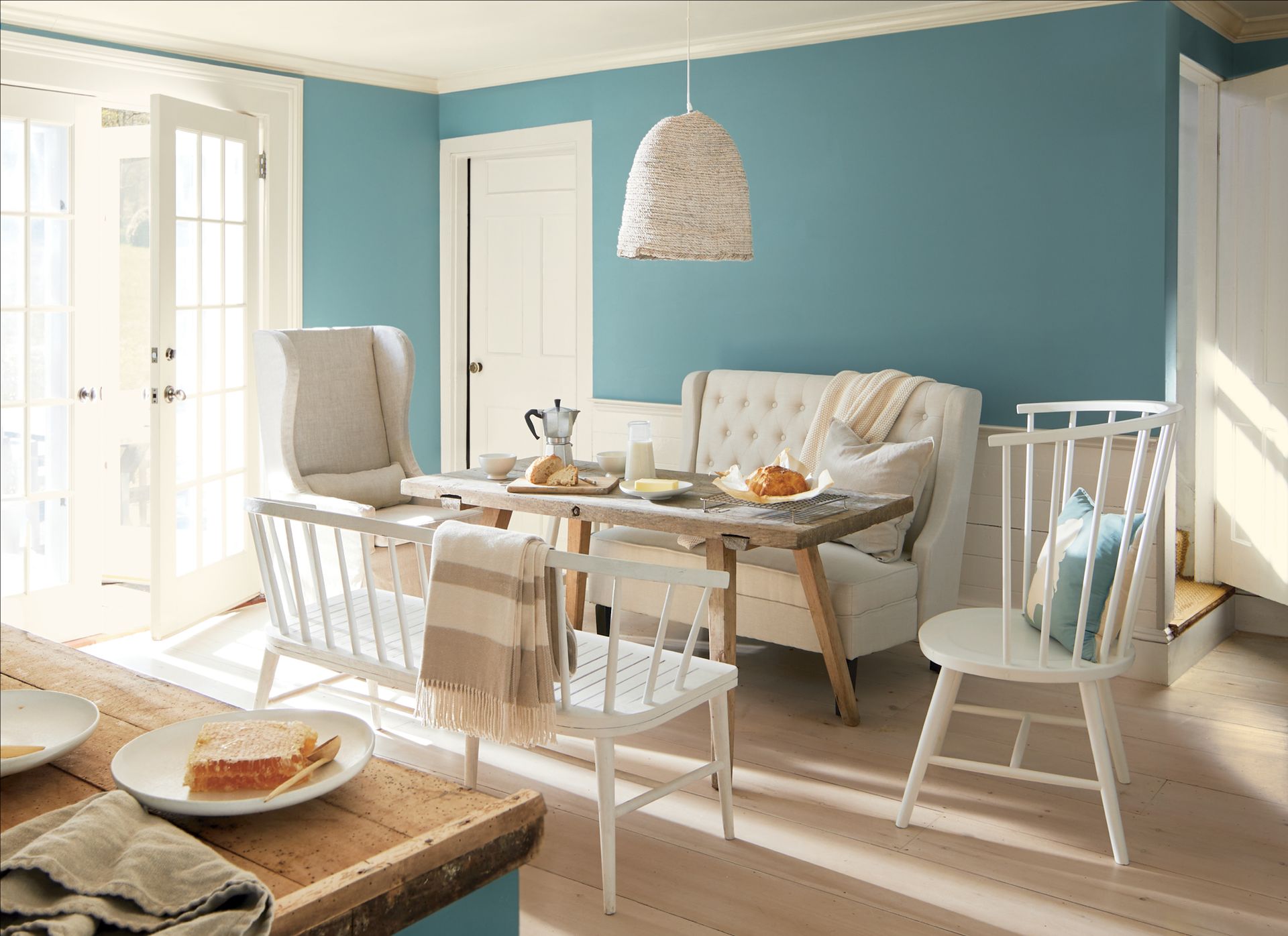 A dining room with a table and chairs and blue walls.