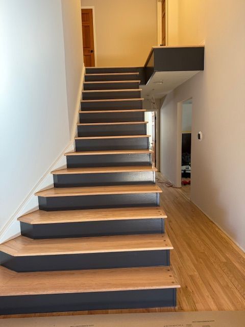 Interior stairway with dark steps and wooden floors in a modern home