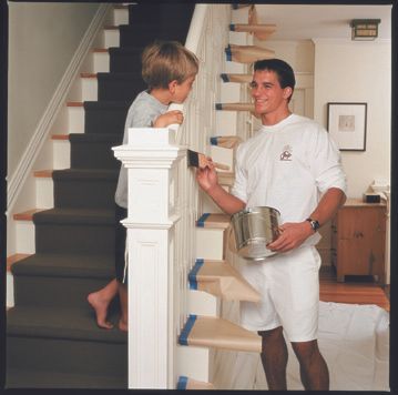 a kitchen with white cabinets , a table and chairs .