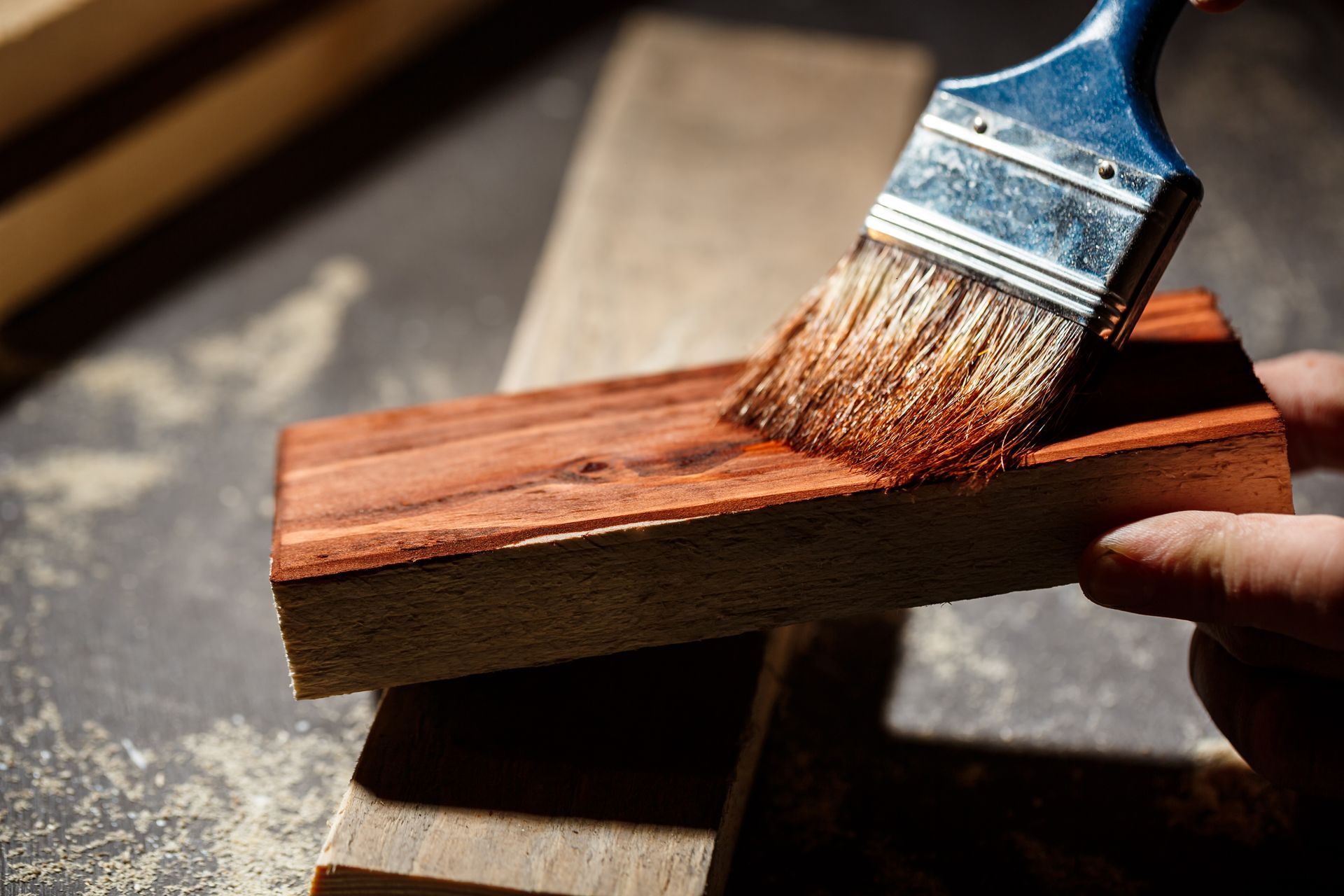 a person is painting a piece of wood with a brush