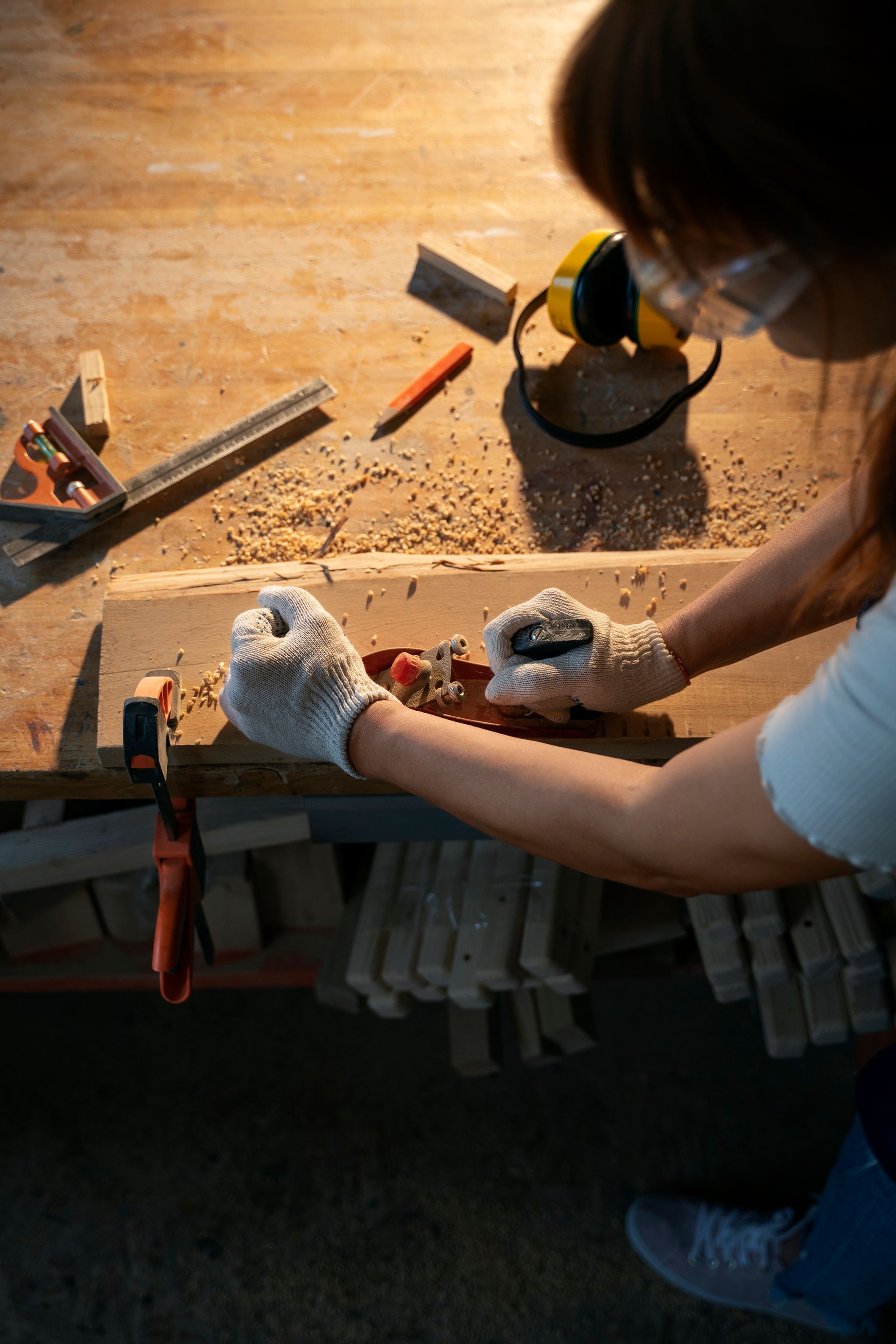 a woman is working on a piece of wood on a wooden table .