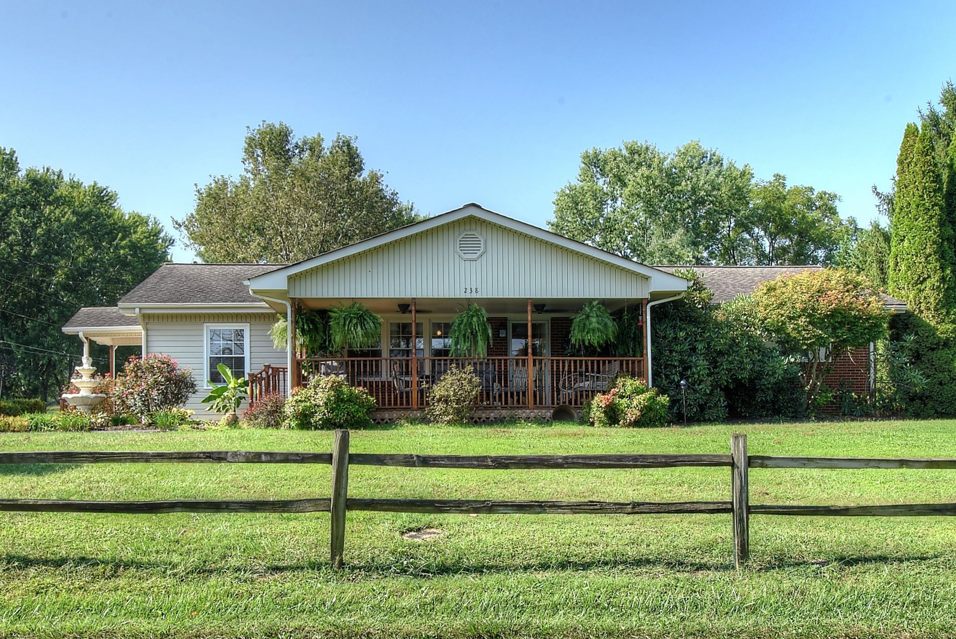 A house with a porch and a wooden fence in front of it
