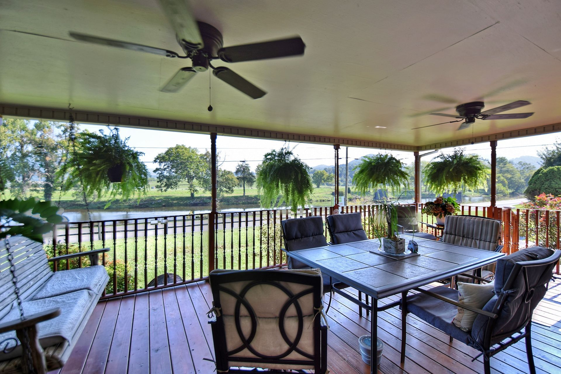 A porch with a table and chairs and a ceiling fan