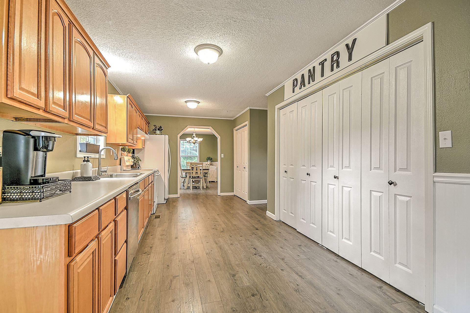 A kitchen with wooden cabinets and a pantry on the wall.