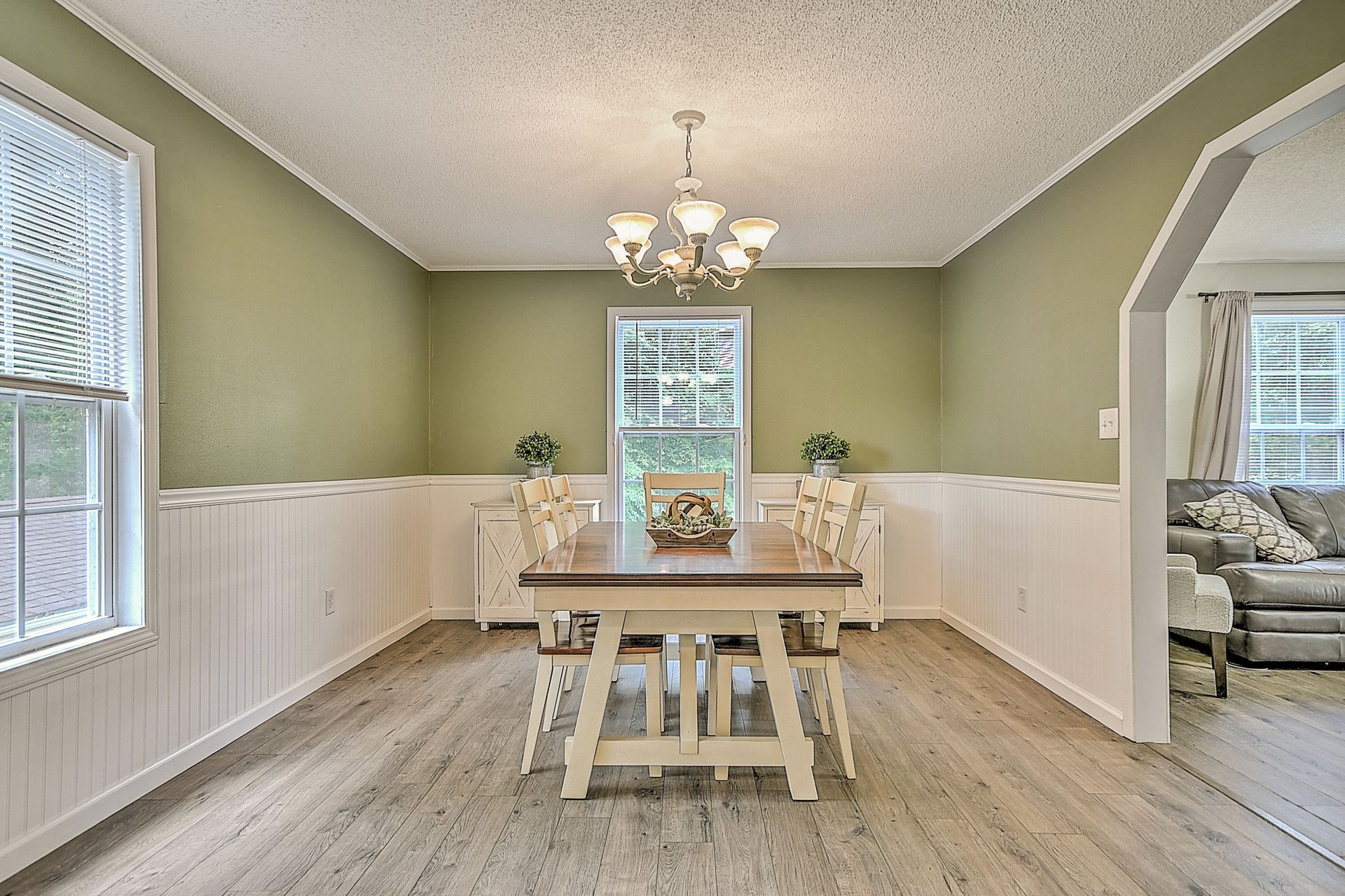 A dining room with a table and chairs and a chandelier.
