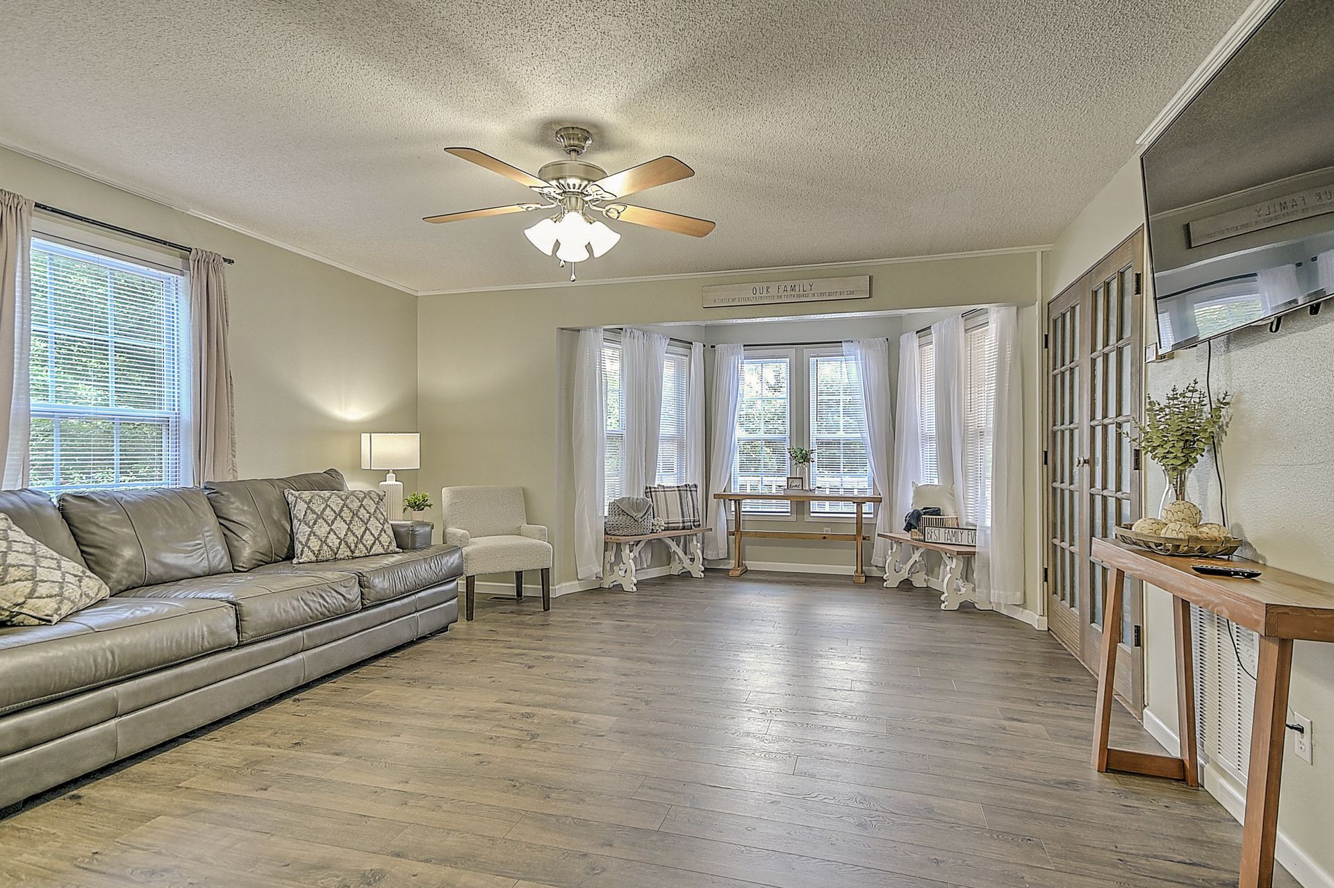A living room with a couch , chairs , and a ceiling fan.