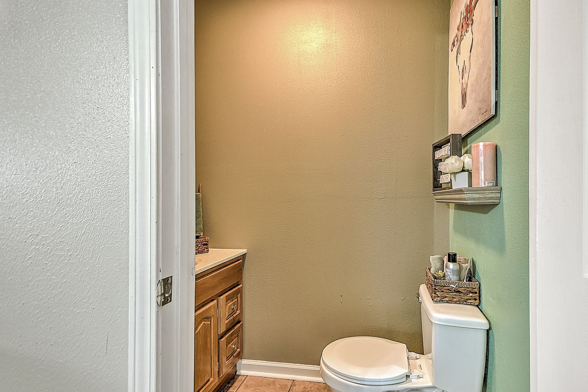 A bathroom with a toilet , sink and mirror.