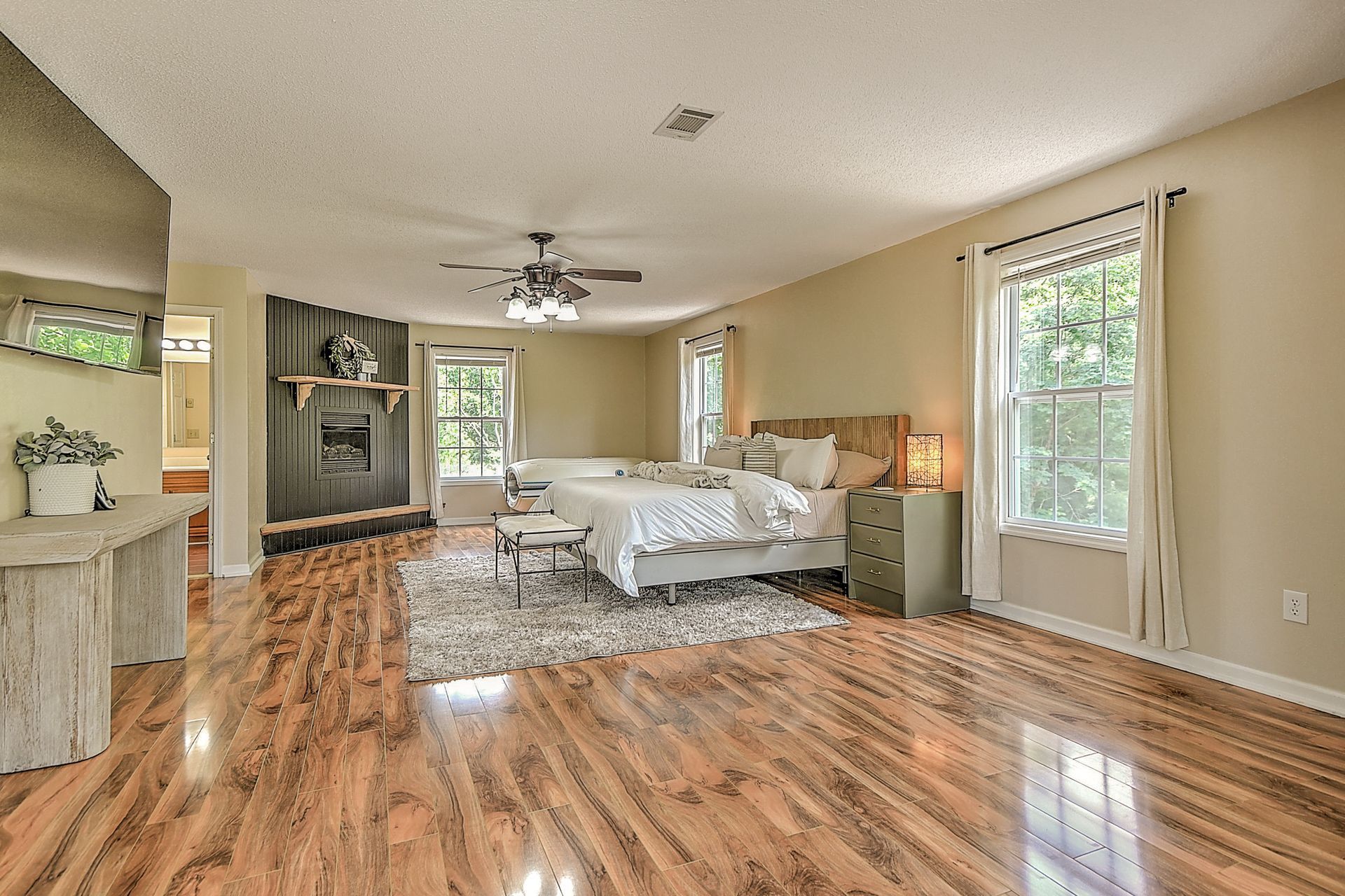 A large bedroom with hardwood floors and a large bed.