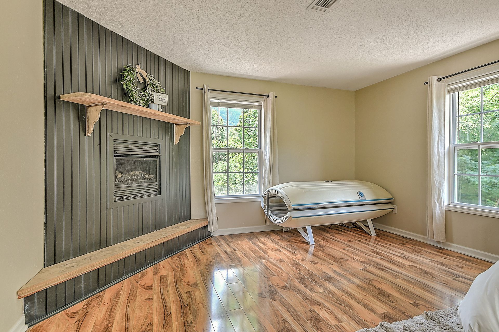 A living room with hardwood floors and a fireplace.