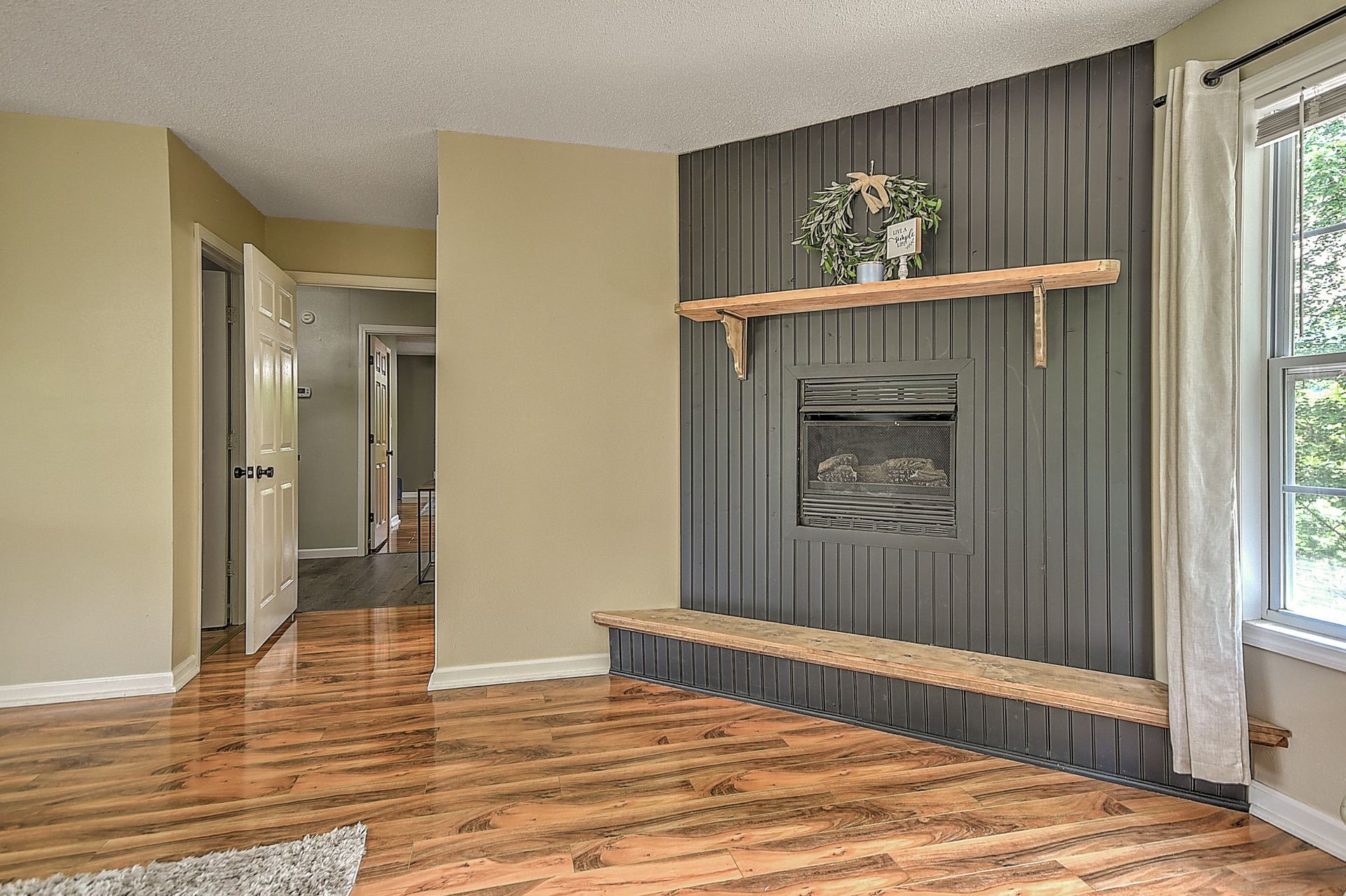 A living room with hardwood floors and a fireplace.