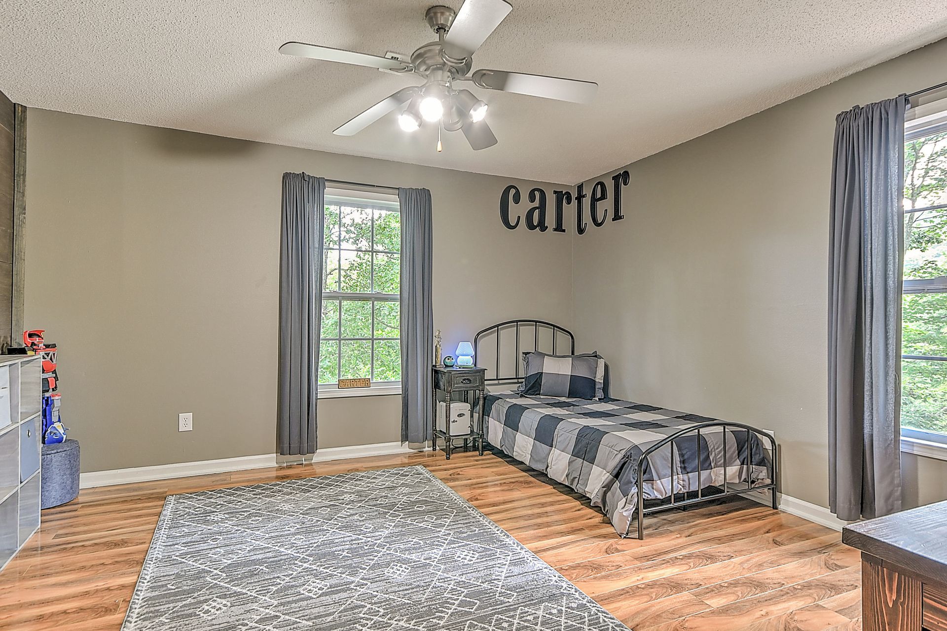 A bedroom with a bed and a ceiling fan.