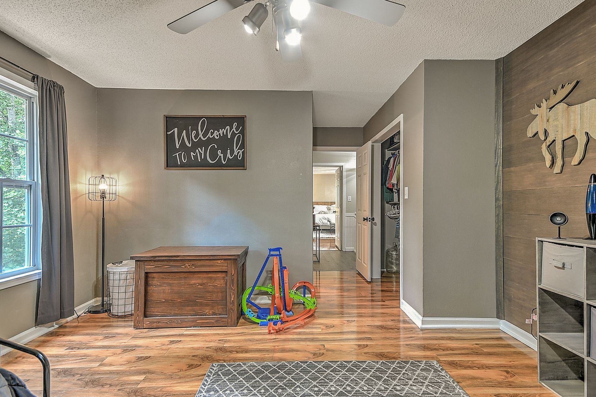 A living room with hardwood floors and a ceiling fan.