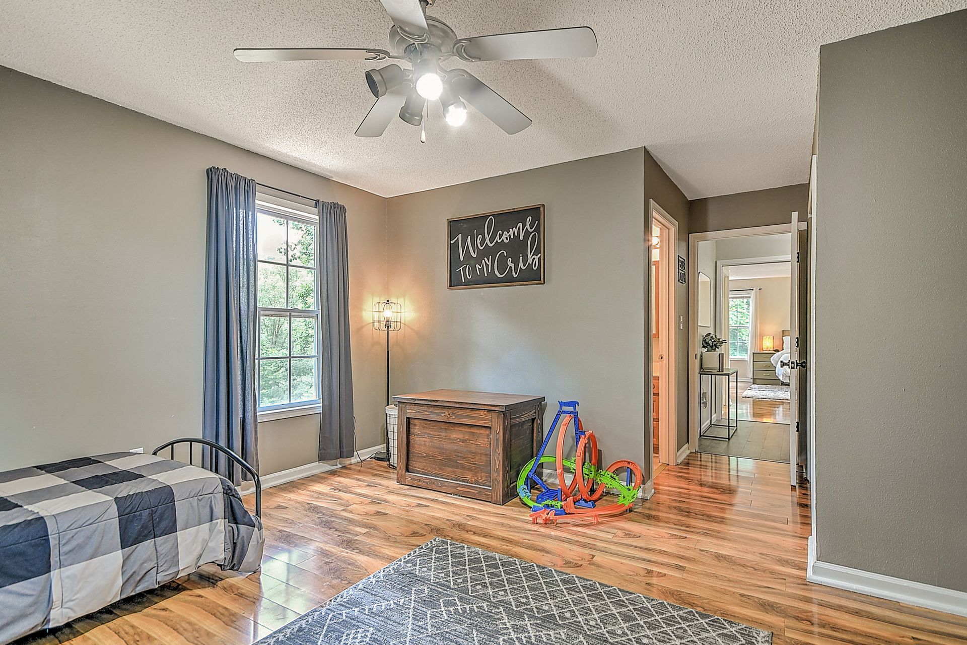 A bedroom with a bed and a ceiling fan.