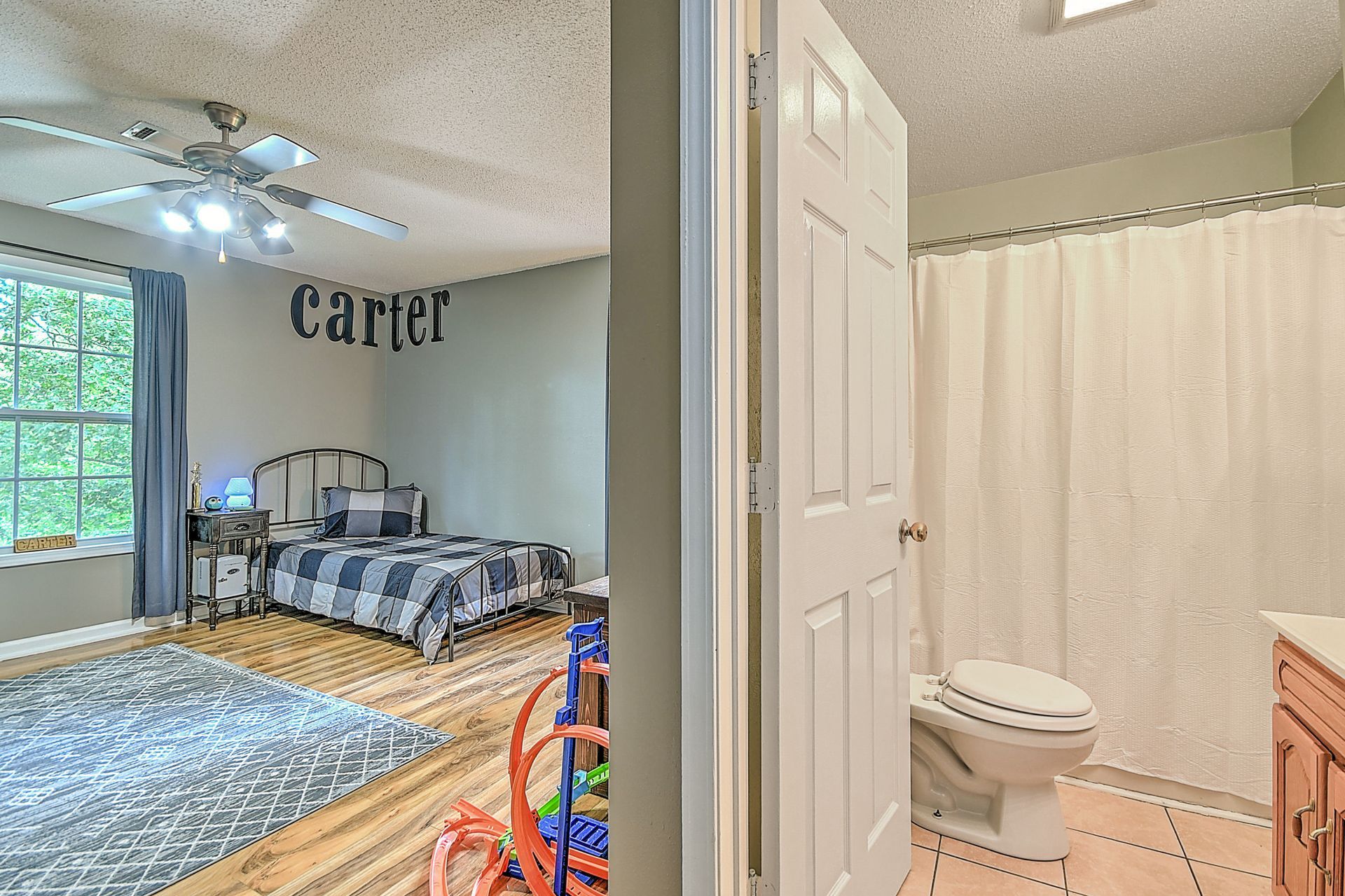 A bedroom with a bed and a bathroom with a toilet.