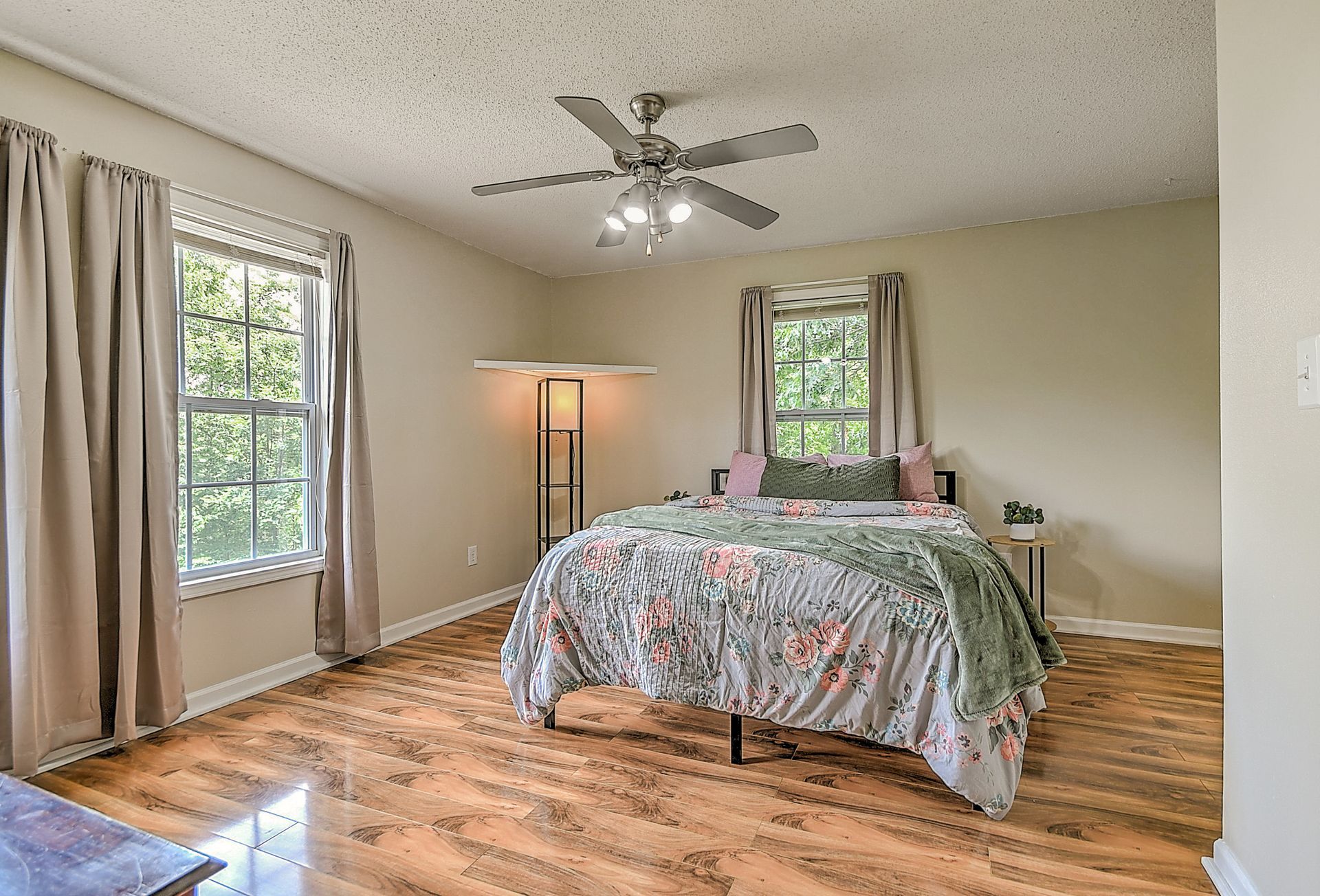 A bedroom with a bed and a ceiling fan.