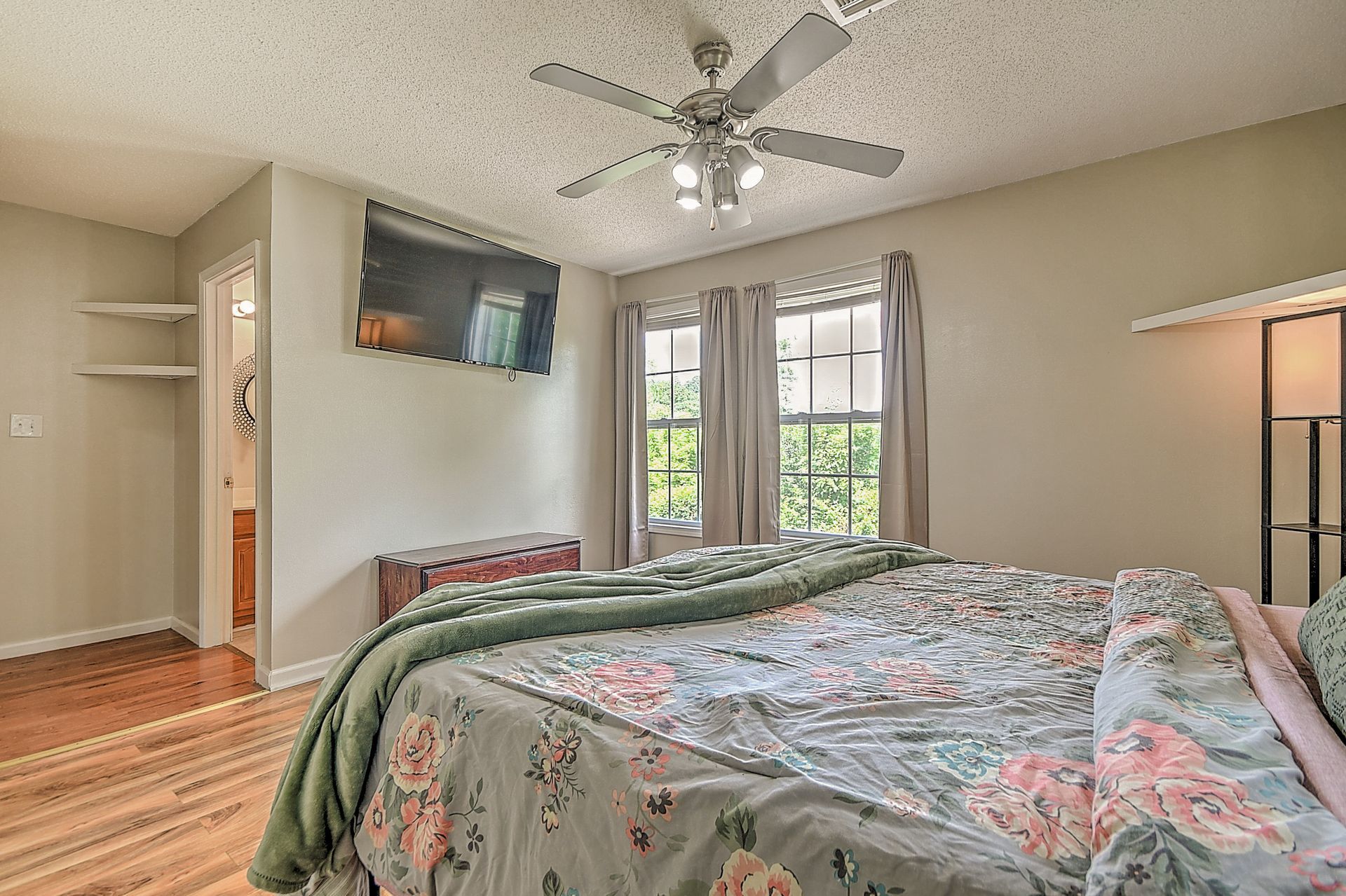 A bedroom with a bed and a ceiling fan.