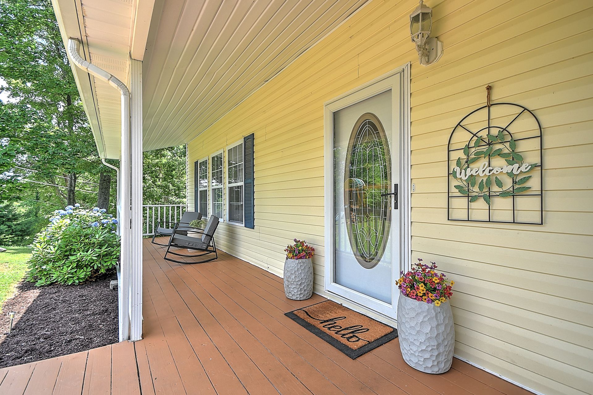 The front porch of a house with a welcome mat on it