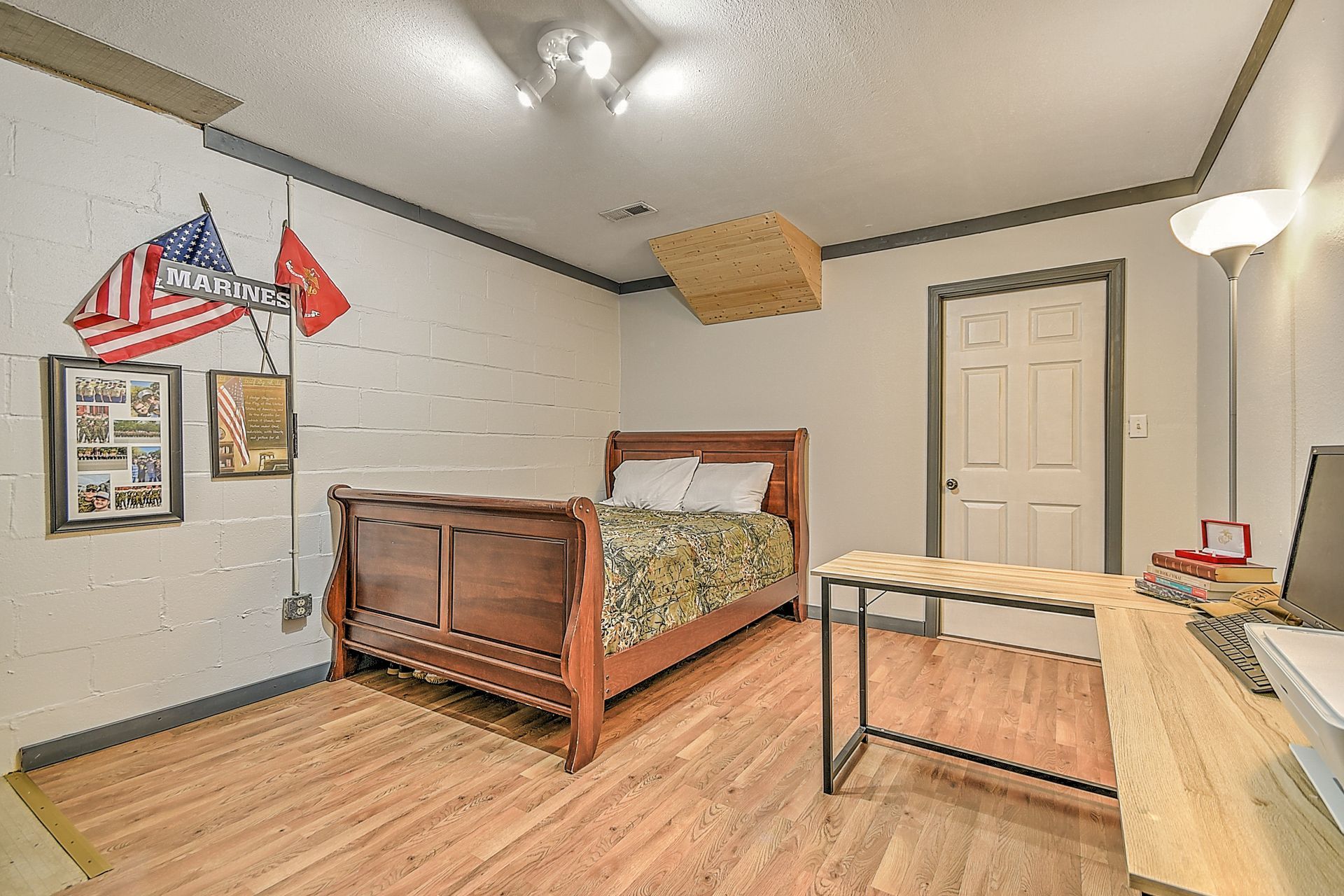 A bedroom with a bed , desk and computer.