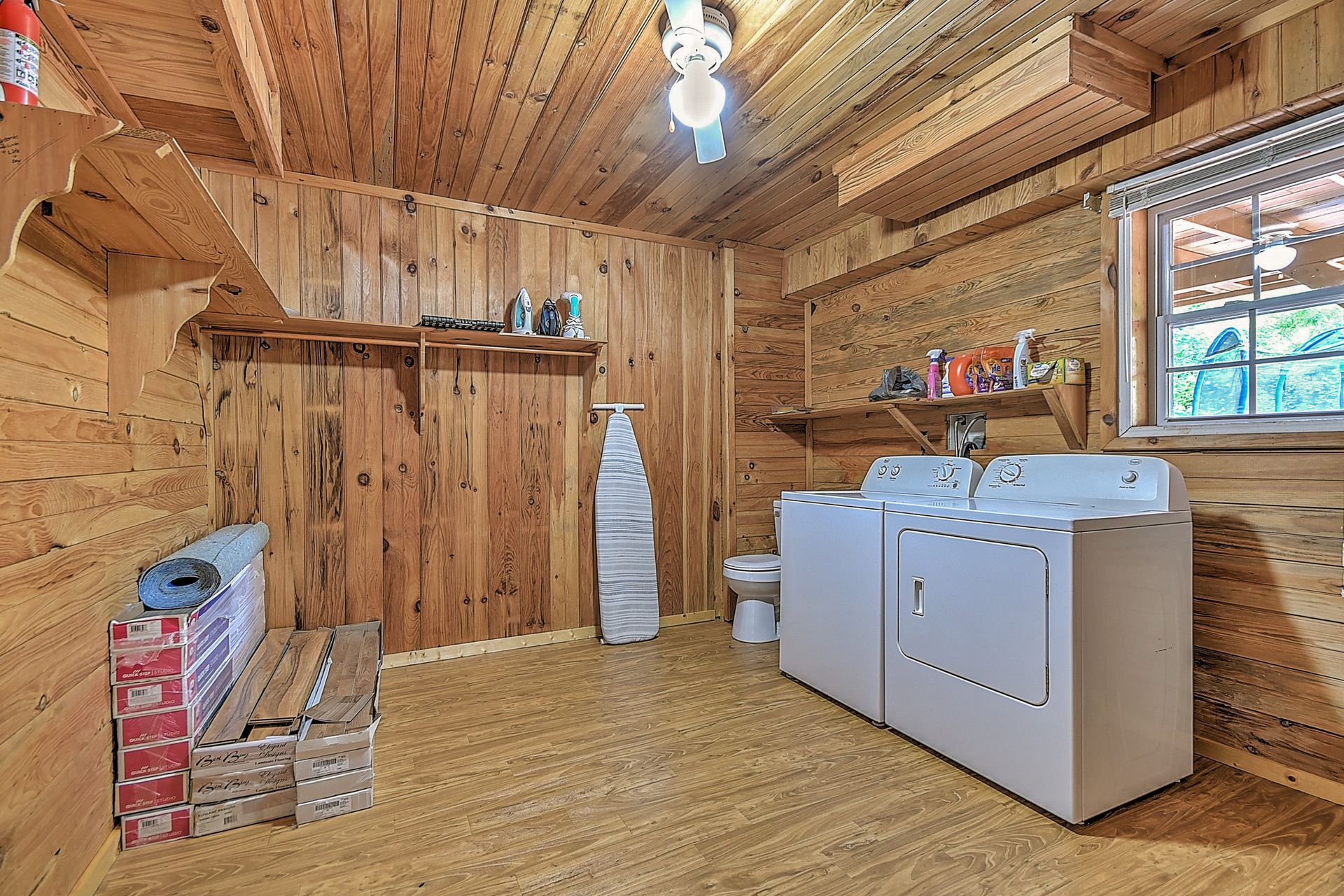 A laundry room in a log cabin with a washer and dryer.