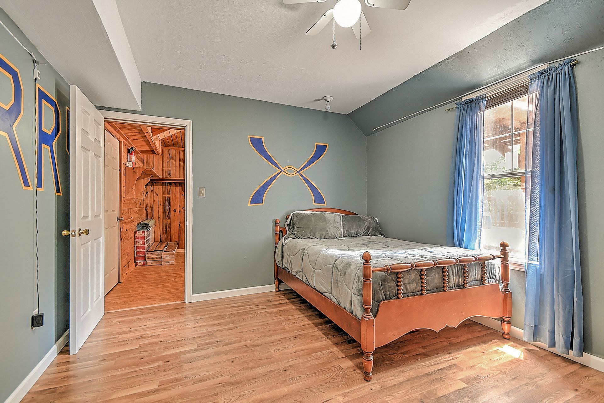 A bedroom with a bed and a ceiling fan