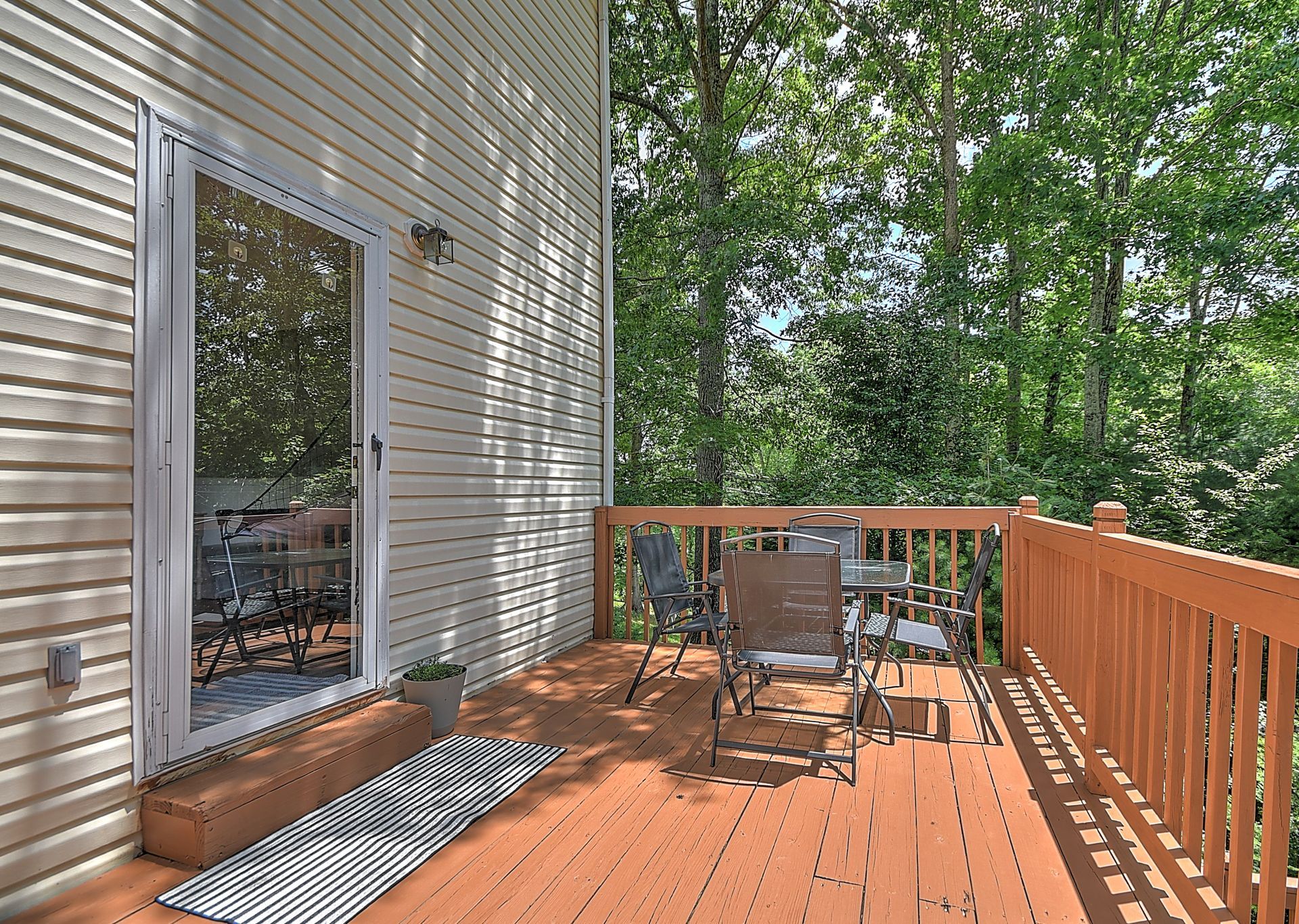 A wooden deck with a table and chairs on it