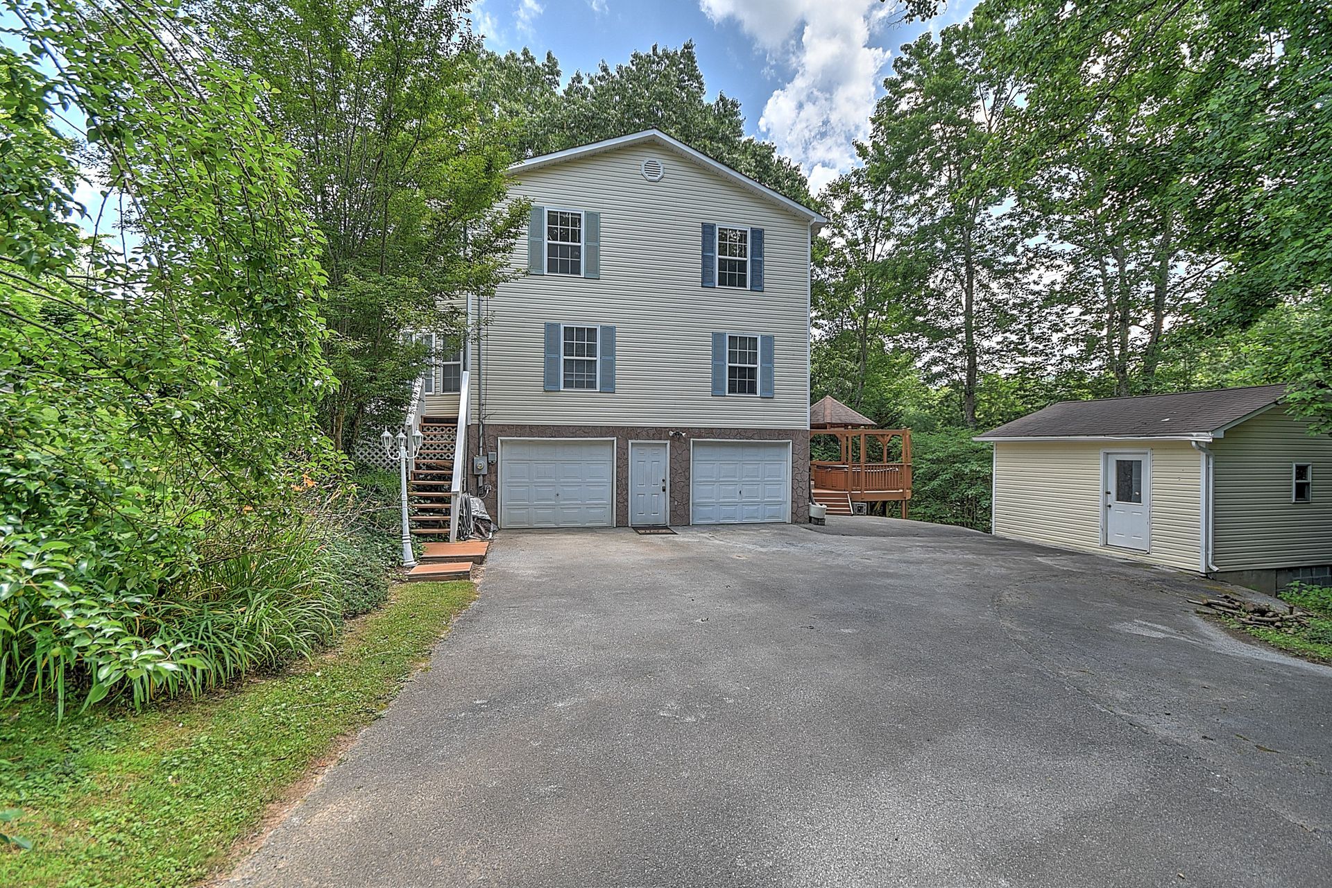 A house with two garages and a shed in front of it
