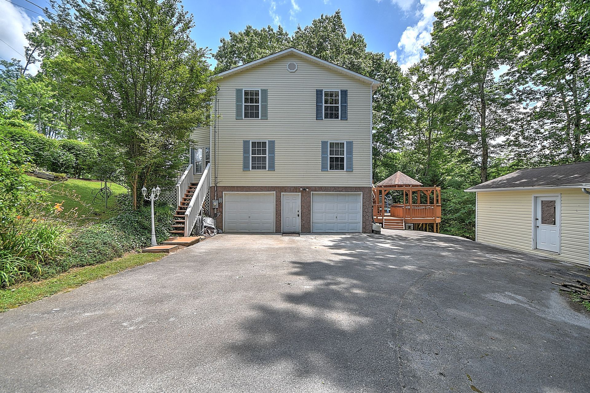A house with two garages and a shed in front of it