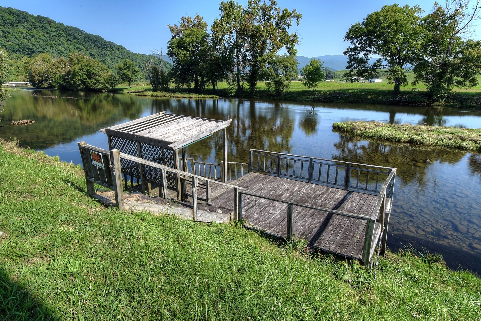 A wooden dock is sitting on the shore of a lake.