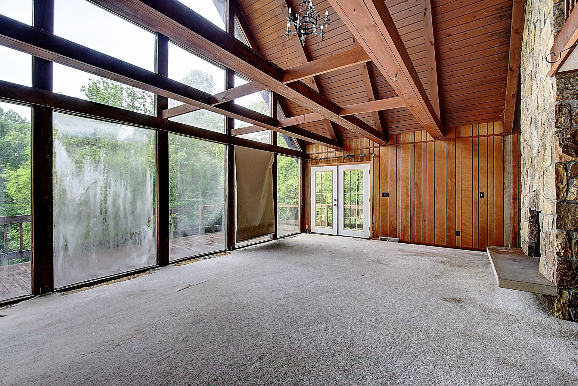 An empty room with a lot of windows and a stone wall