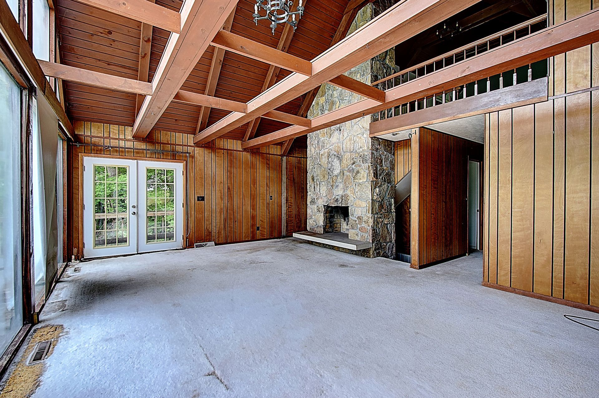 An empty room with wood paneling and a fireplace