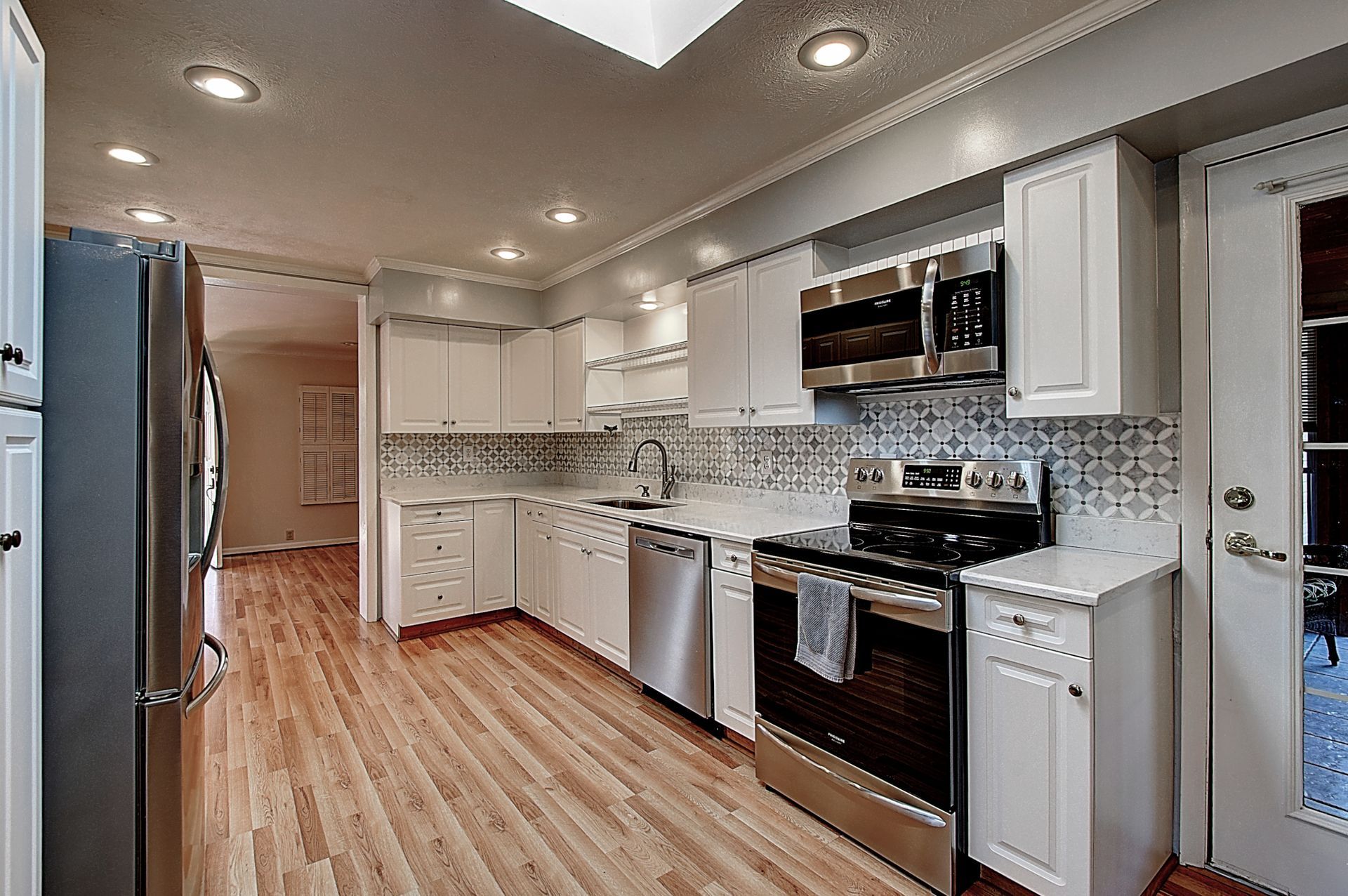 A kitchen with white cabinets and stainless steel appliances