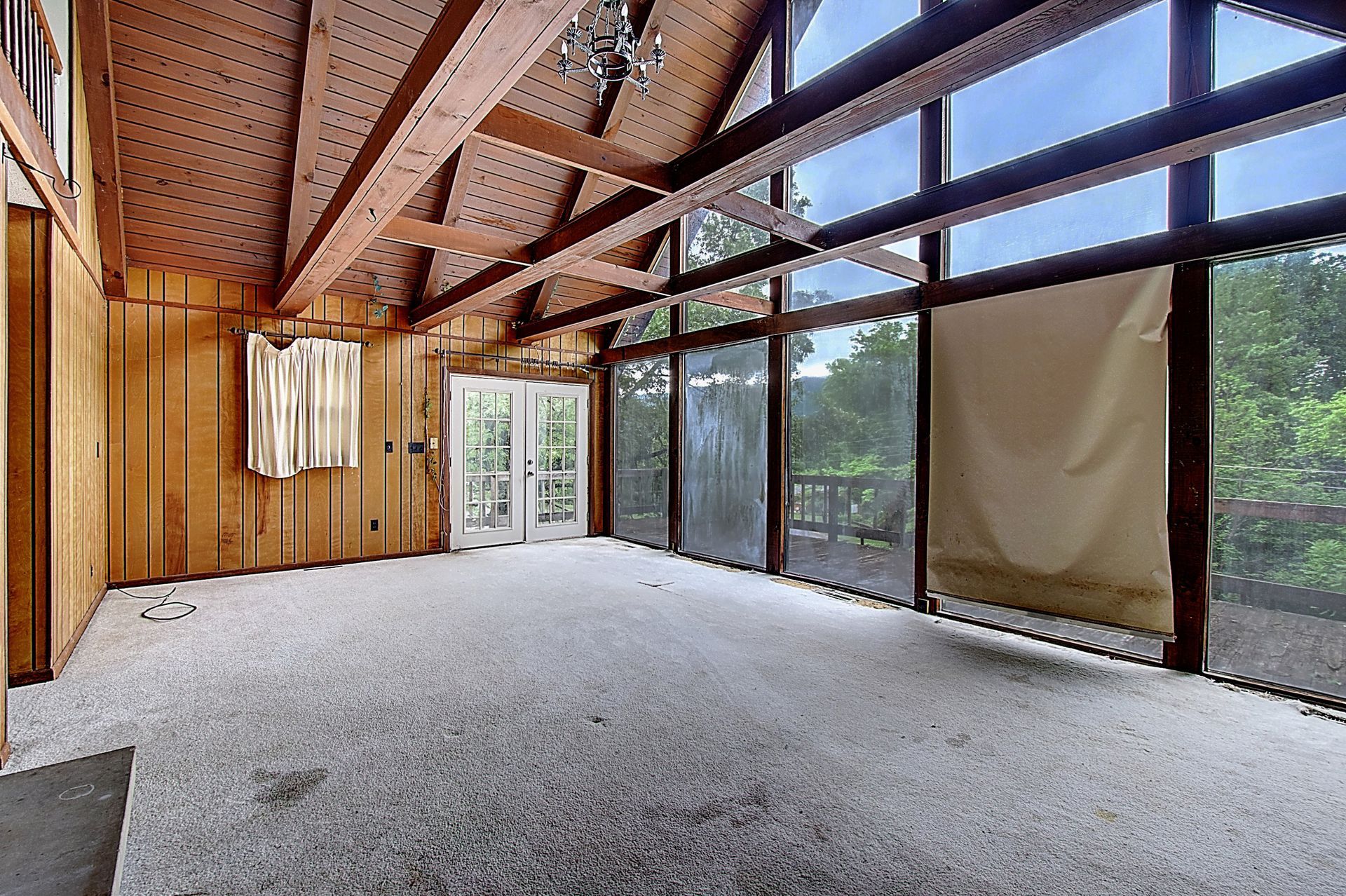 An empty room with a lot of windows and wood paneling