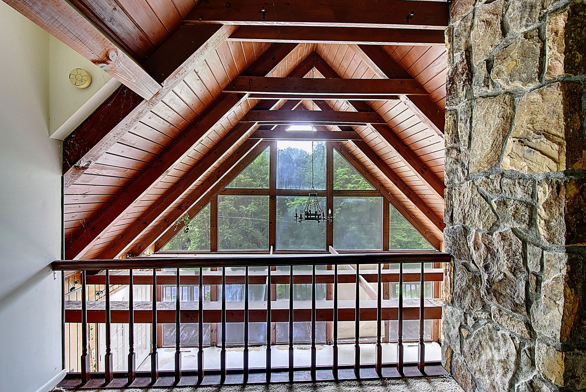 An attic with a large window and a stone wall
