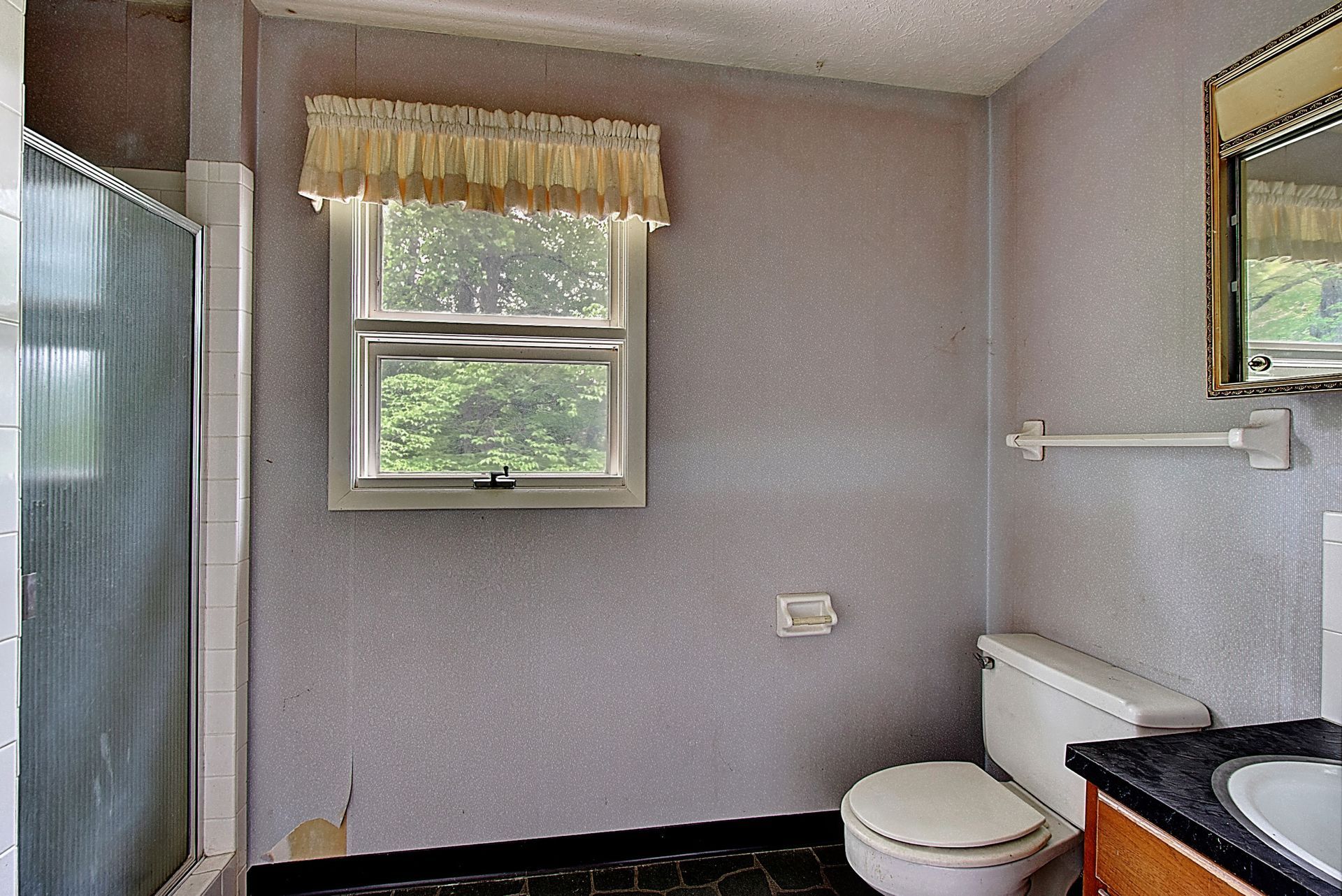 A bathroom with a toilet a sink and a window